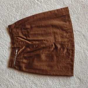 Bronze mini skirt with zipper accent in back and slit.